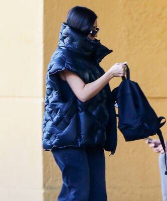 Ким Кардашьян - Дутая жилетка Louis Vuitton, которую Ким Кардашьян носит с очень длинными джинсами - elle.ru